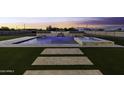 Backyard with a luxurious pool and spa area, featuring a cascading waterfall design and artificial grass at 19912 E Karsten Dr, Queen Creek, AZ 85142
