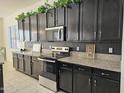 Kitchen with dark cabinets, granite counters, and stainless steel appliances at 4072 S Skyline Ct, Gilbert, AZ 85297