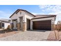 Attractive stucco home with stone pillar accents, two car garage, and desert landscaping at 42103 N Cutbow Trl, San Tan Valley, AZ 85140