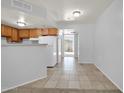 Kitchen with wood cabinets, white appliances, and a view of a hallway at 12221 W Bell Rd # 187, Surprise, AZ 85378