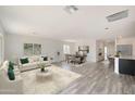 Open living room with wood-look floors and access to kitchen and dining area at 1344 W Inca Dr, Coolidge, AZ 85128
