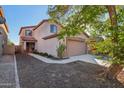 Two-story house with walkway, landscaping, and a tree at 1409 E Harvest Rd, San Tan Valley, AZ 85140