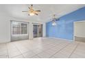 Bright living room with tile flooring, ceiling fans, and access to the backyard at 1427 E Irwin Ave, Phoenix, AZ 85042