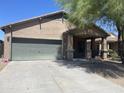 Front view of a single-story house with a green garage door at 42554 W Lucera Ct, Maricopa, AZ 85138