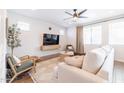 Bright living room with sofa, chairs, and a large TV at 5323 W Chuck Box Rd, Laveen, AZ 85339