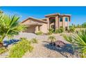 Beautiful two-story home featuring an arched entryway and a well-maintained front yard with mature trees at 12015 S Tuzigoot Dr, Phoenix, AZ 85044