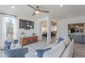 Bright living room featuring a large window, comfortable seating, and wood-look floors at 12015 S Tuzigoot Dr, Phoenix, AZ 85044