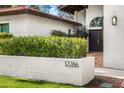 Front entrance with dark brown door and lush green hedge at 12286 N 86Th Pl, Scottsdale, AZ 85260