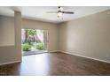 Living room with dark hardwood floors and sliding glass door to patio at 14145 N 92Nd St # 1052, Scottsdale, AZ 85260