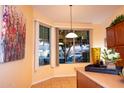 Bright breakfast nook features pendant lighting, an abstract painting, and large bay windows at 5028 S Peachwood Dr, Gilbert, AZ 85298