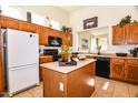 Well-equipped kitchen featuring wood cabinets, an island, and black appliances at 5028 S Peachwood Dr, Gilbert, AZ 85298