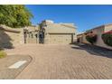 Tan two-story home with a three-car garage and a brick paved driveway at 6202 E Mckellips Rd # 91, Mesa, AZ 85215