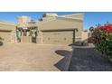 Tan two-story home with a three-car garage and a brick paved driveway at 6202 E Mckellips Rd # 91, Mesa, AZ 85215