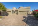 Tan two-story home with a three-car garage and a brick paved driveway at 6202 E Mckellips Rd # 91, Mesa, AZ 85215