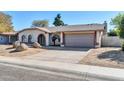 House exterior featuring a two-car garage and desert landscaping at 7357 W Canterbury Dr, Peoria, AZ 85345