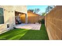 Small backyard with artificial turf, patio, and block wall for privacy at 18611 N 22Nd St # 2, Phoenix, AZ 85024