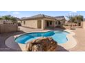 Inviting kidney shaped pool with a large stone feature at 2832 E Flower St, Gilbert, AZ 85298