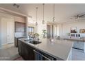 Bright kitchen featuring a spacious island with a sink, stylish pendant lights, and modern finishes at 30039 N 209Th Ave, Wittmann, AZ 85361