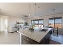 Open-concept kitchen boasts a large island, pendant lighting, and seamless flow into the living area at 30039 N 209Th Ave, Wittmann, AZ 85361