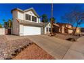 Two story house with white garage door and rock landscaping, view from street at 5416 E Glencove St, Mesa, AZ 85205