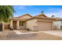 Tan house with a two-car garage and landscaped yard at 6703 W Linda Ln, Chandler, AZ 85226