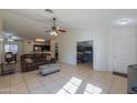Living room with a brown leather sofa, tile floor, and access to other rooms at 1643 E Bishop Dr, Casa Grande, AZ 85122
