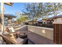 Cozy patio with wicker chairs and a small table, overlooking a community yard at 20771 W Windsor Blvd, Buckeye, AZ 85396