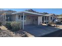 Mobile home exterior with carport and desert landscaping at 2233 E Behrend Dr # 197, Phoenix, AZ 85024