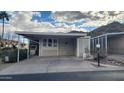 Tan mobile home with carport and desert landscaping at 2233 E Behrend Dr # 197, Phoenix, AZ 85024