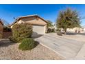 Tan house with a two-car garage and driveway, side yard view at 28452 N Crimm Rd, San Tan Valley, AZ 85143