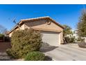 Tan house with a two-car garage, side yard view with desert landscaping at 28452 N Crimm Rd, San Tan Valley, AZ 85143
