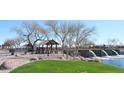Scenic entrance to Rancho Mirage featuring water feature, green space, and desert landscaping at 38133 W Vera Cruz Dr, Maricopa, AZ 85138