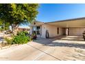 Mobile home with carport and lush landscaping at 437 E Germann Rd # 24, San Tan Valley, AZ 85140