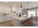 Open concept kitchen with island, white cabinetry, and breakfast nook at 27017 N 153Rd Dr, Surprise, AZ 85387