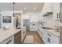 Modern kitchen boasts white cabinets, quartz countertops, and stainless steel appliances at 27017 N 153Rd Dr, Surprise, AZ 85387