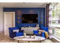 Living room features blue accent wall, comfy seating, and large TV at 3242 E Camelback Rd # 105, Phoenix, AZ 85018