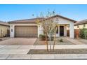 Tan colored house with a two-car garage and nicely landscaped yard at 19436 S 208Th Pl, Queen Creek, AZ 85142