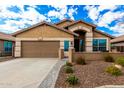 Tan house with a two-car garage and nicely landscaped yard at 20472 N 90Th Ln, Peoria, AZ 85382