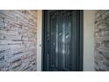 Close up of a sleek, ornate, secure, metal front door surrounded by stone detailing at 4119 S Las Villa Way, Gold Canyon, AZ 85118