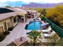 Inviting backyard oasis with a sparkling pool, outdoor kitchen, and scenic mountain views at 4119 S Las Villa Way, Gold Canyon, AZ 85118