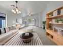 Bright and airy living room with comfortable seating and built-in shelving at 41876 W Corvalis Ln, Maricopa, AZ 85138
