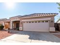 House exterior featuring tan walls, tile roof, and a two-car garage at 4233 E Colonial Dr, Chandler, AZ 85249