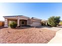 Tan house with tile roof, two-car garage, and desert landscaping at 4233 E Colonial Dr, Chandler, AZ 85249