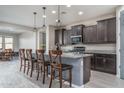 Modern kitchen with dark cabinets, granite counters, and an island at 7332 W Quail Track Dr, Peoria, AZ 85383