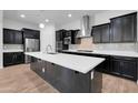 Modern kitchen with dark cabinets, stainless steel appliances, and a large white countertop island at 10141 E Stealth Ave, Mesa, AZ 85212