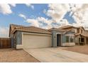 Single story home with a two-car garage and neutral-colored exterior at 1922 N Wildflower Ln, Casa Grande, AZ 85122