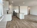 Modern kitchen with white cabinets, stainless steel appliances, and a stylish kitchen island at 24098 W Sunland Ave, Buckeye, AZ 85326