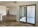 Spacious living room featuring wood-style flooring and a sliding glass door to the patio at 24098 W Sunland Ave, Buckeye, AZ 85326