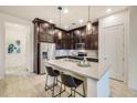 Modern kitchen with dark cabinetry, stainless steel appliances, and a kitchen island at 6565 E Thomas Rd # 1005, Scottsdale, AZ 85251
