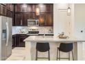 Modern kitchen with dark cabinetry, stainless steel appliances, and a kitchen island at 6565 E Thomas Rd # 1005, Scottsdale, AZ 85251